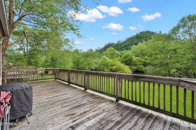 deck with a lawn and area for grilling