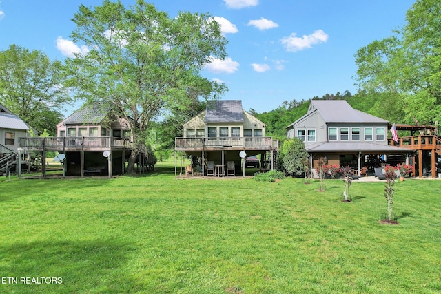 back of property with a lawn and a wooden deck