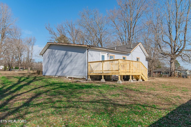 rear view of property featuring a wooden deck and a yard