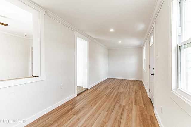 empty room featuring crown molding and light wood-type flooring