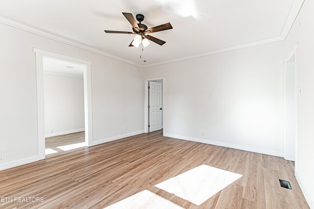 spare room featuring ceiling fan, light wood-type flooring, and crown molding