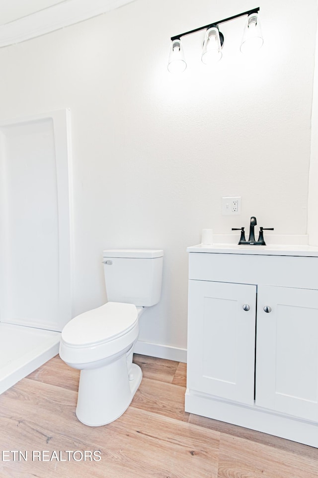 bathroom with hardwood / wood-style floors, vanity, and toilet