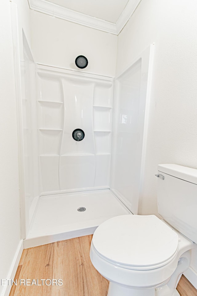 bathroom featuring hardwood / wood-style flooring, crown molding, toilet, and walk in shower