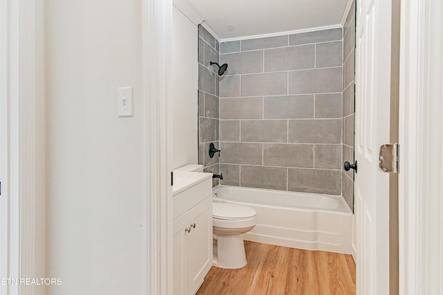 full bathroom with ornamental molding, toilet, hardwood / wood-style flooring, vanity, and tiled shower / bath