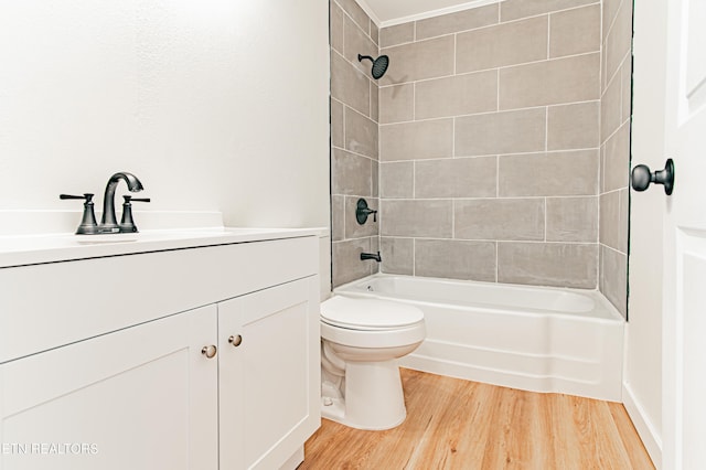 full bathroom with hardwood / wood-style floors, vanity, toilet, and tiled shower / bath