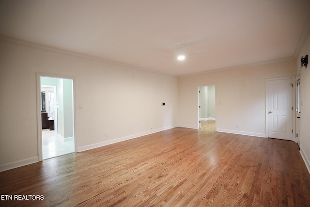 empty room featuring ornamental molding and light wood-type flooring