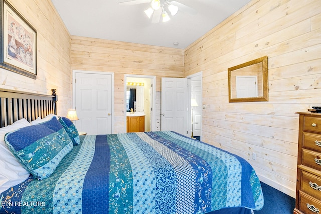 bedroom featuring ceiling fan, wooden walls, and connected bathroom