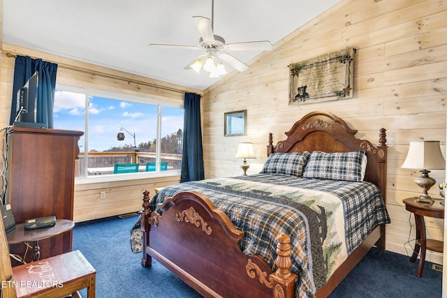 carpeted bedroom with ceiling fan, wood walls, and vaulted ceiling