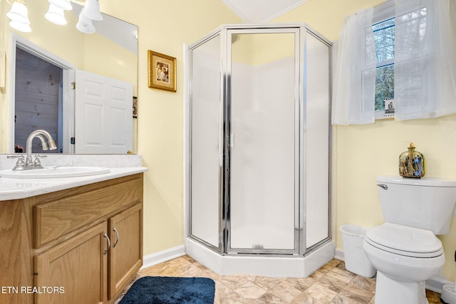 bathroom featuring vanity, toilet, and a shower with door