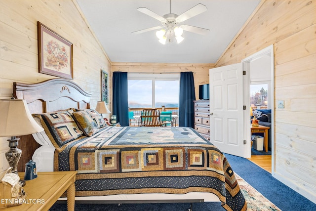 bedroom with ceiling fan, lofted ceiling, and wood walls