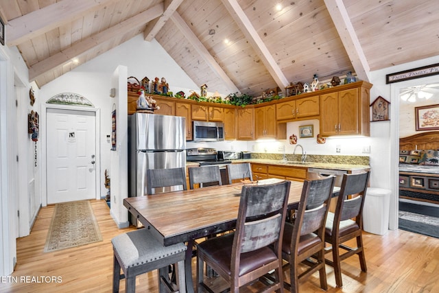 kitchen featuring wood ceiling, stainless steel appliances, ceiling fan, beam ceiling, and light hardwood / wood-style flooring