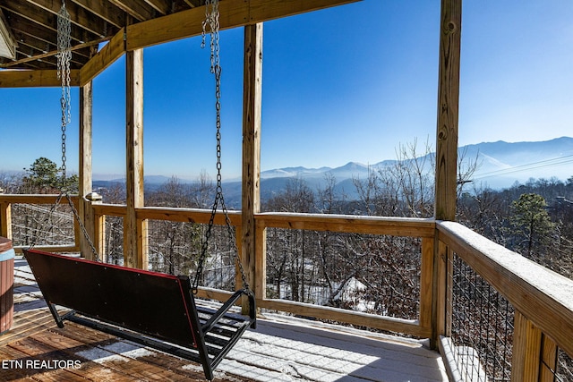 snow covered deck featuring a mountain view