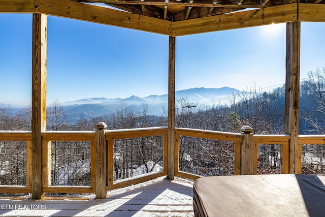 snow covered deck with a mountain view