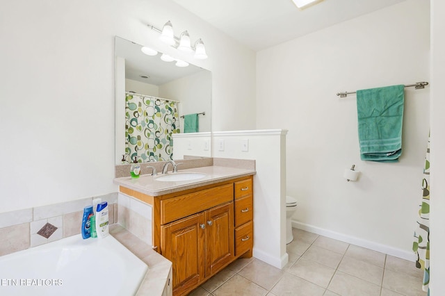 bathroom with tile patterned flooring, vanity, a relaxing tiled tub, and toilet