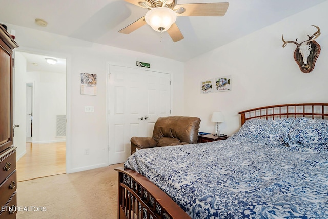 bedroom featuring ceiling fan, light carpet, and a closet