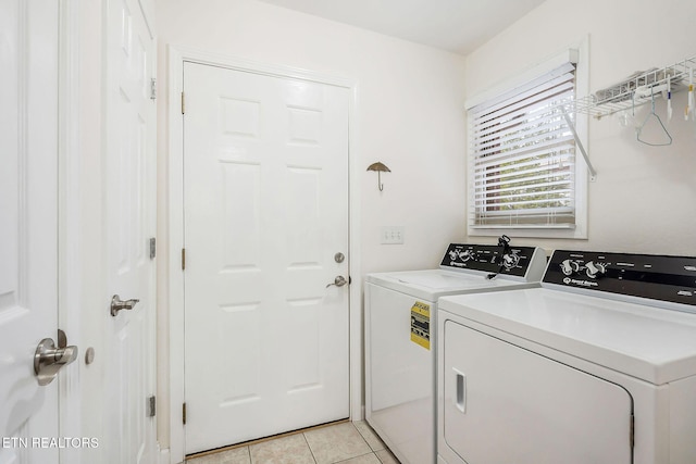 laundry room with washing machine and dryer and light tile patterned floors