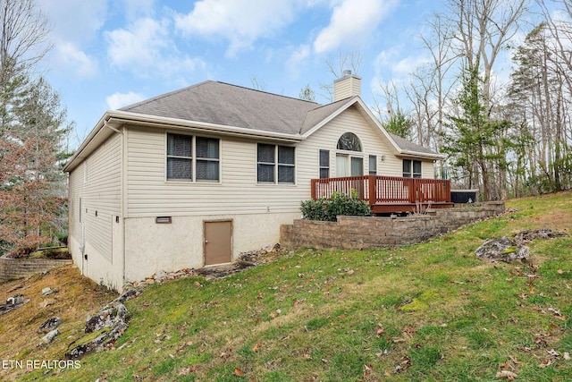 back of property with a lawn and a wooden deck