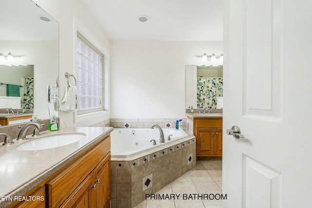 bathroom featuring tile patterned flooring, vanity, and tiled bath