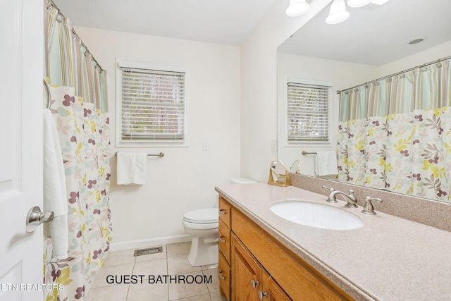 bathroom with tile patterned flooring, vanity, and toilet