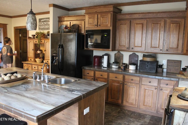 kitchen with tile counters, black appliances, and sink