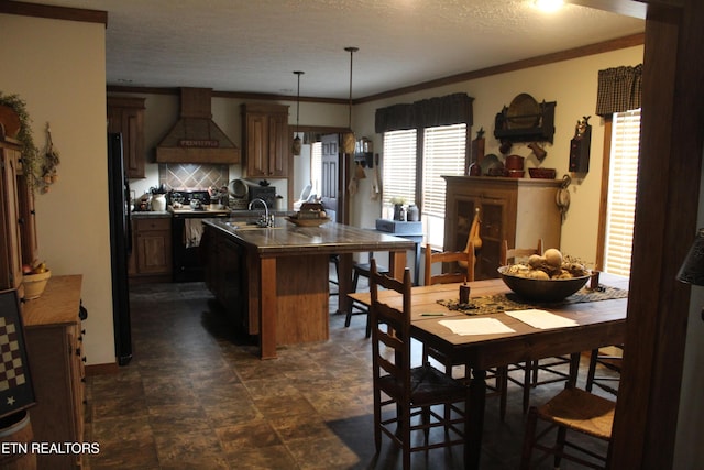 dining room with sink, a textured ceiling, and ornamental molding