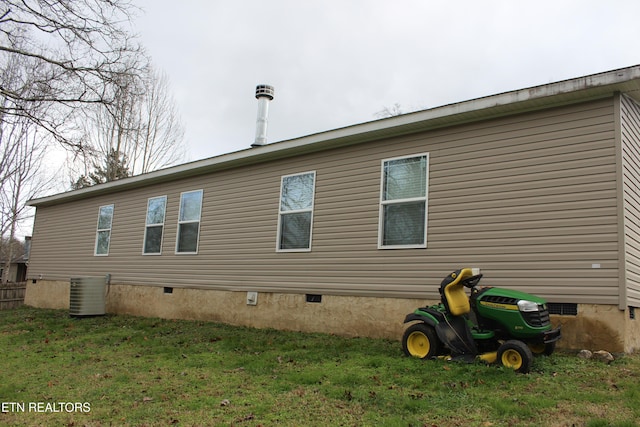 view of home's exterior featuring cooling unit and a lawn