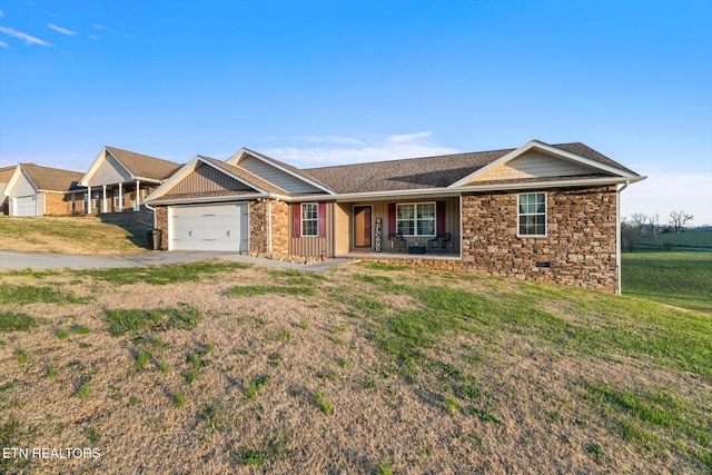 ranch-style house with covered porch, a garage, and a front yard