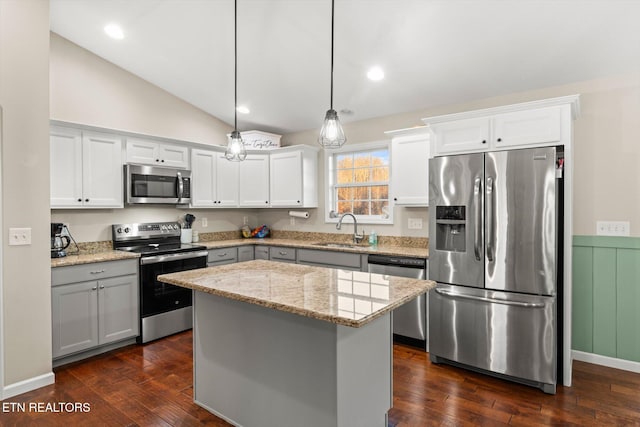 kitchen with sink, a center island, decorative light fixtures, white cabinets, and appliances with stainless steel finishes