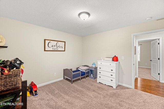 bedroom with a textured ceiling and light colored carpet