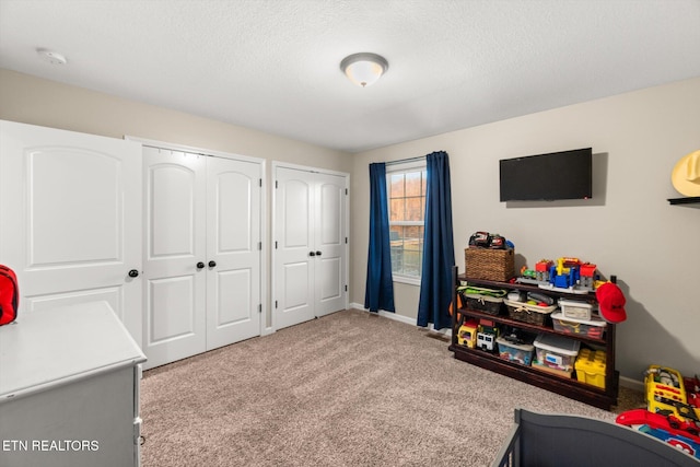 recreation room featuring carpet and a textured ceiling