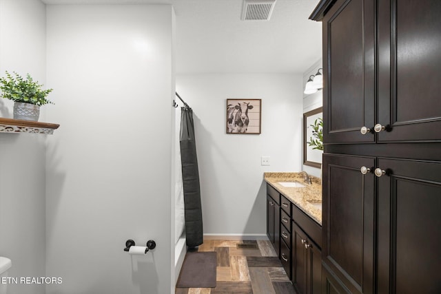 bathroom featuring vanity, toilet, and parquet floors