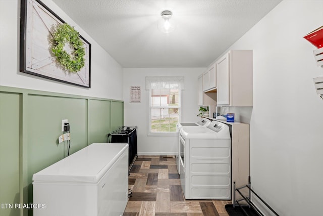 laundry room featuring washer and clothes dryer and cabinets