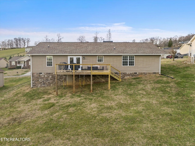 rear view of house featuring a wooden deck and a yard