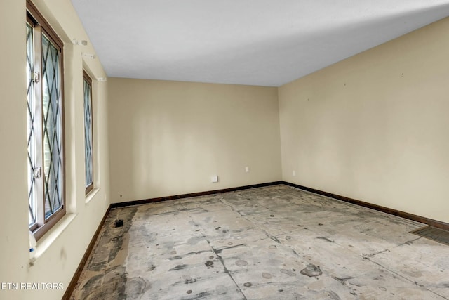 unfurnished room with baseboards and visible vents