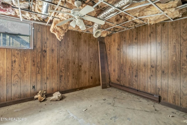 below grade area with a baseboard heating unit and wooden walls