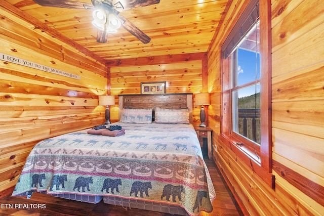 bedroom with ceiling fan, wood walls, and wood ceiling