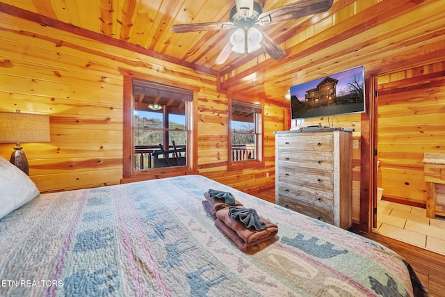 bedroom featuring wooden ceiling, access to outside, ceiling fan, and wooden walls