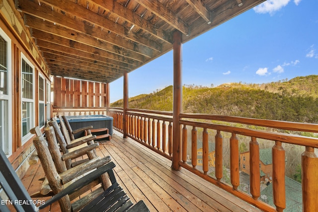 wooden deck featuring a hot tub