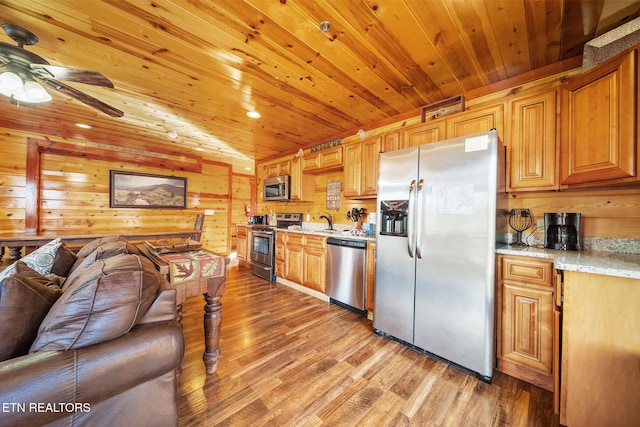 kitchen with light stone countertops, sink, wooden ceiling, light hardwood / wood-style flooring, and appliances with stainless steel finishes