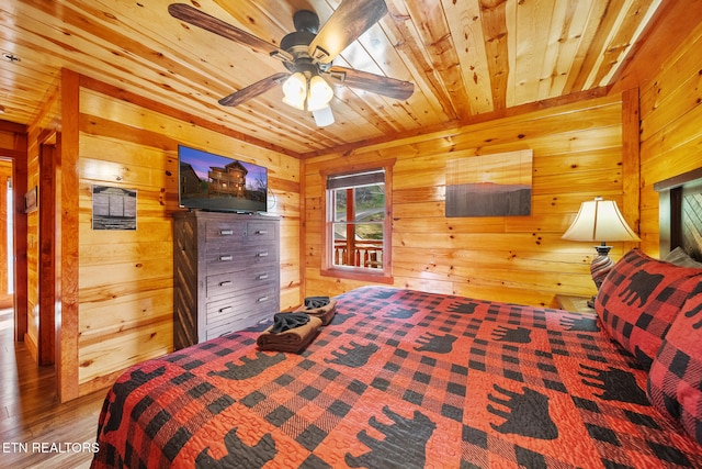 bedroom with wood walls, ceiling fan, wood ceiling, and hardwood / wood-style flooring