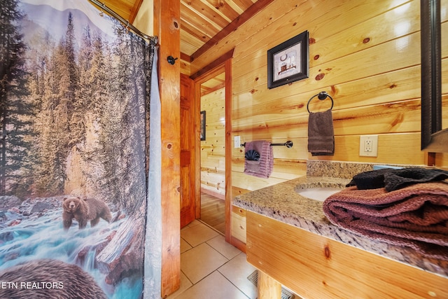 bathroom with vanity, wooden ceiling, tile patterned floors, and wooden walls