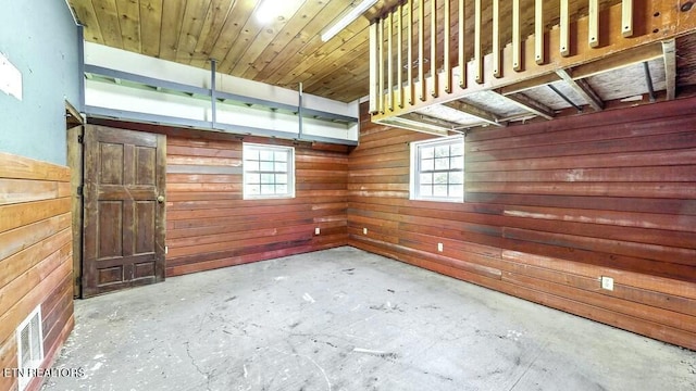 empty room featuring concrete flooring and wooden walls