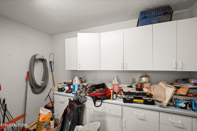 kitchen featuring white cabinets and a textured ceiling