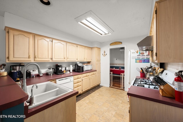 kitchen with ceiling fan, sink, wall chimney range hood, white appliances, and light brown cabinetry