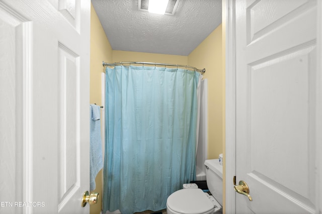 bathroom featuring toilet, a textured ceiling, and shower / tub combo with curtain