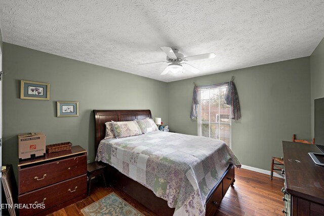 bedroom featuring a textured ceiling, dark hardwood / wood-style floors, and ceiling fan