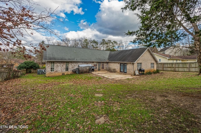 back of house featuring a lawn and a patio area