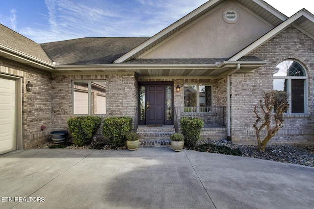 property entrance with covered porch and a garage