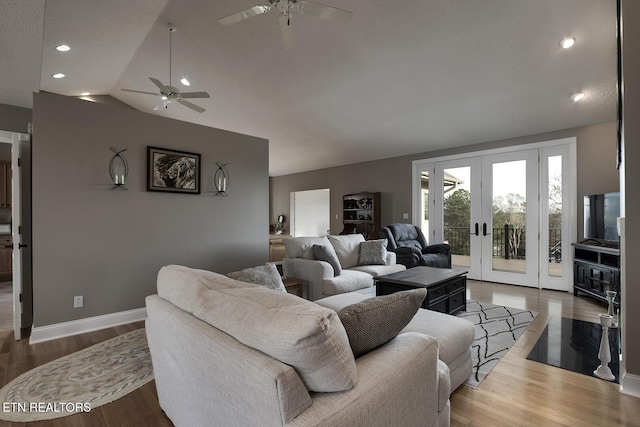 living room featuring ceiling fan, wood-type flooring, french doors, and vaulted ceiling