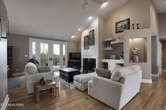 living room featuring hardwood / wood-style flooring, high vaulted ceiling, and ceiling fan